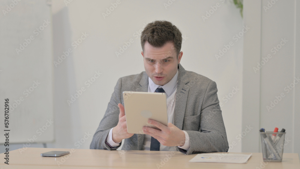 Young Businessman Reacting to Loss on Digital Tablet Young Businessman Reacting to Loss on Digital Tablet