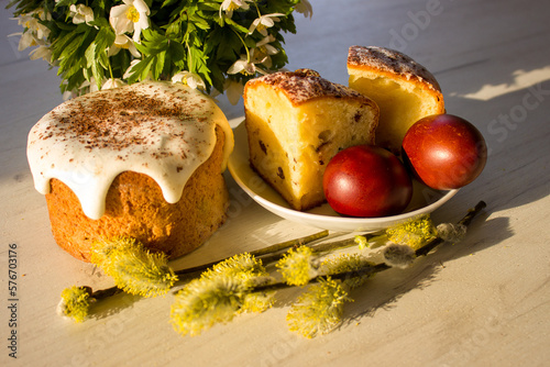 Traditional Ukrainian Sweet Easter Bread in the sunshine. Easter cake decorated with red egs and first spring flowers. Easter cookies. Homemade cookies. Easter day. Snowdrops.