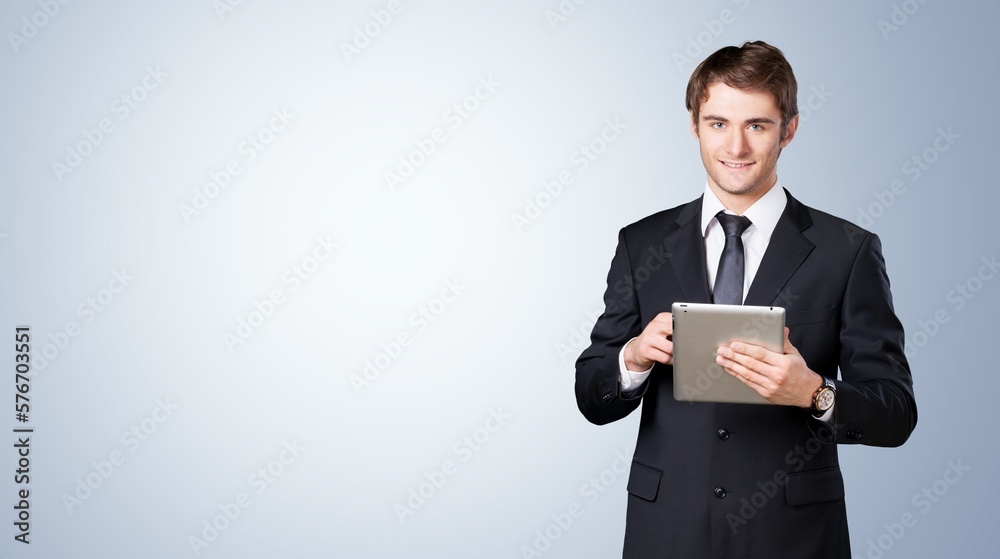 Cheerful young business man works on digital tablet Cheerful young business man works on digital tablet