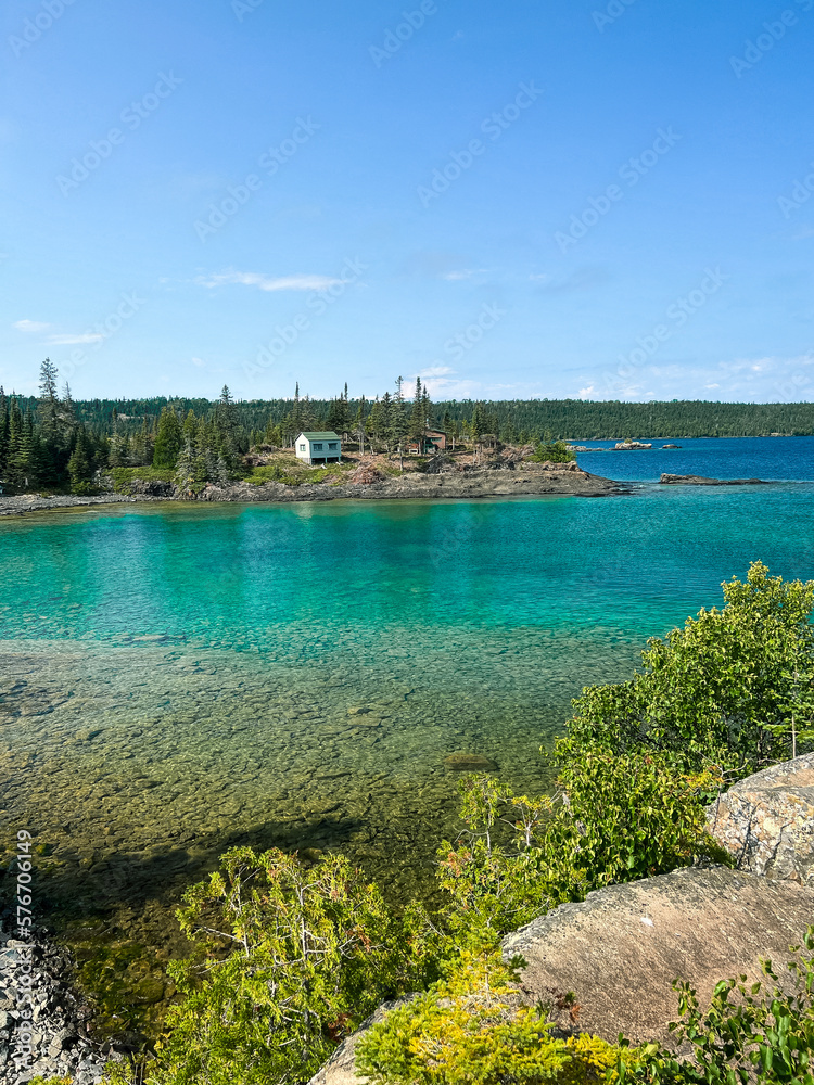 Spectacular Views of Lake Superior from a Rocky Cliff at Isle Royale National Park. A rustic cottage can be seen in the distance.