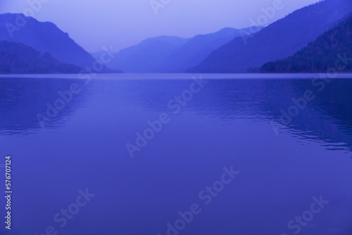 Lake Teletskoye, Altai Republic, Russia. Blue clear sky and Mirror of lake. Abstract panoramic landscape with natural gradient blue color, nature environment scene, monochrome background