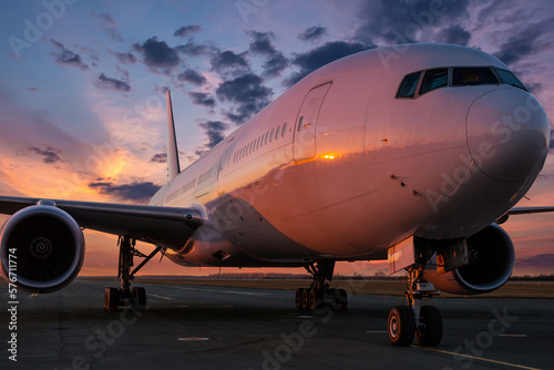Wide body passenger airliner at the airport apron against the backdrop of a picturesque evening sky
