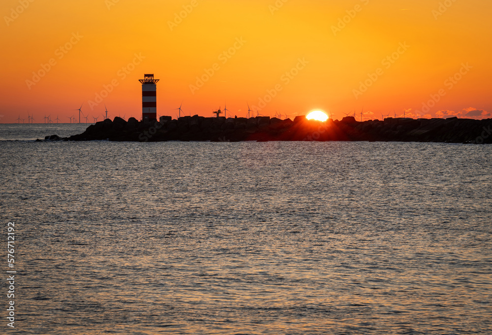Lighthouse at the north pier Ijmuiden in The Netherlands by sunset