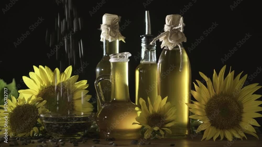 Sunflower seeds are poured into a glass bowl. Sunflower oil, yellow sunflower flowers and sunflower seeds for the manufacture of oil Sunflower seeds are poured into a glass bowl. Sunflower oil, yellow sunflower flowers and sunflower seeds for the manufacture of oil