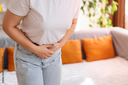 Young woman suffering from severe abdominal pain, Close-up