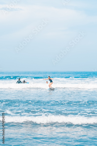 The man is surfing. A novice surfer on the waves in the ocean off the coast of Asia on the island of Bali in Indonesia.