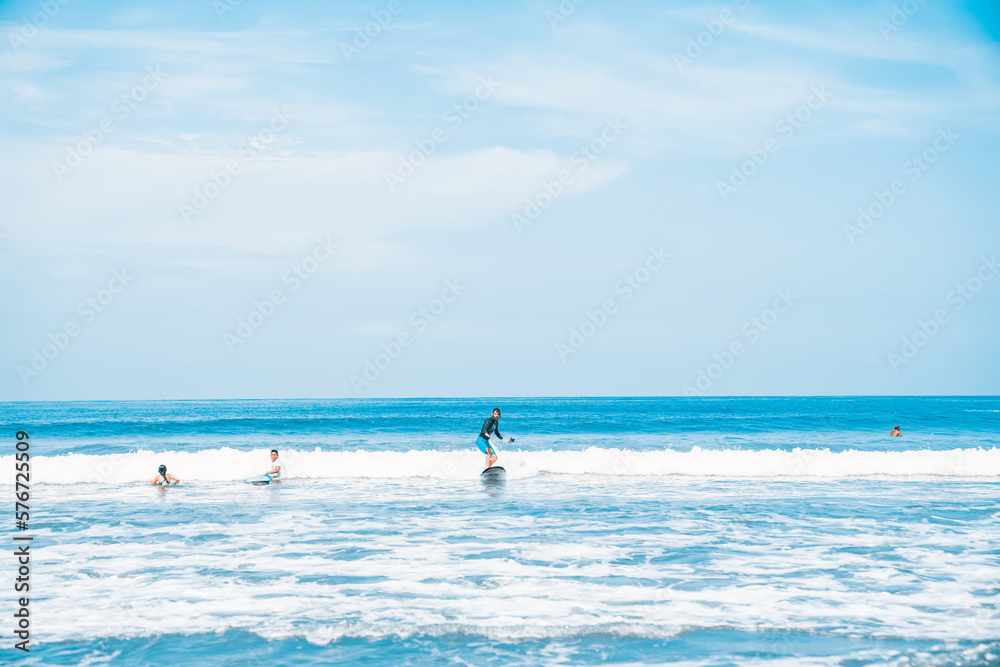 The man is surfing. A novice surfer on the waves in the ocean off the coast of Asia on the island of Bali in Indonesia.