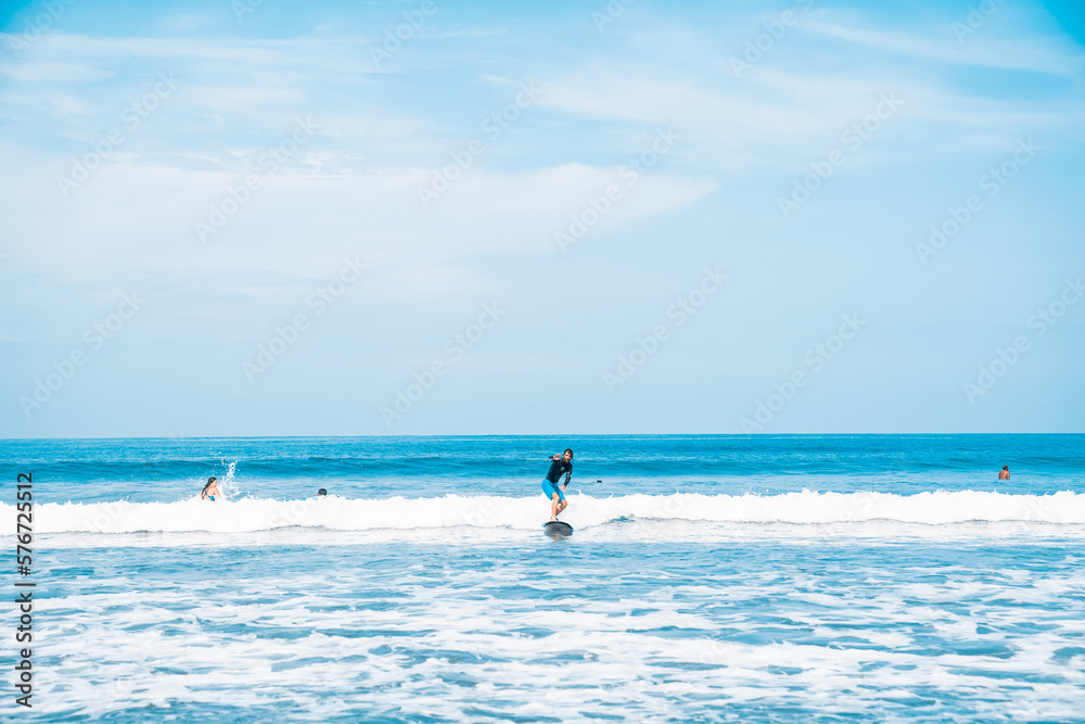 The man is surfing. A surfer on the waves in the ocean off the coast of Asia on the island of Bali in Indonesia. Sports and extreme. Beauty and health. Fashion and beach style.