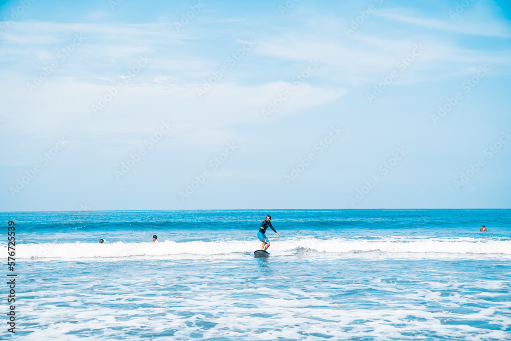 The man is surfing. A surfer on the waves in the ocean off the coast of Asia on the island of Bali in Indonesia. Sports and extreme. Beauty and health. Fashion and beach style.