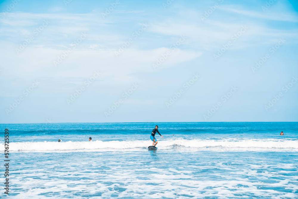The man is surfing. A surfer on the waves in the ocean off the coast of Asia on the island of Bali in Indonesia. Sports and extreme. Beauty and health. Fashion and beach style. The man is surfing. A surfer on the waves in the ocean off the coast of Asia on the island of Bali in Indonesia. Sports and extreme. Beauty and health. Fashion and beach style.