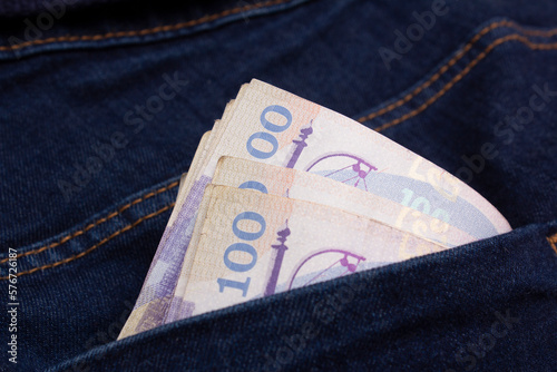 100 GEL sticking out of pocket of blue denim pants. Teen pocket money. Cash paper Georgian banknote. One hundred lari to pay for purchase, debt, loan, utility bills. Currency exchange concept. Budget