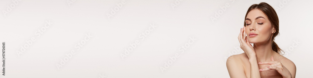 Young beautiful woman with perfect smooth skin isolated over grey studio background. Tenderness and sensuality. Banner. Concept of natural beauty, plastic surgery, cosmetology, cosmetics, skin care Young beautiful woman with perfect smooth skin isolated over grey studio background. Tenderness and sensuality. Banner. Concept of natural beauty, plastic surgery, cosmetology, cosmetics, skin care
