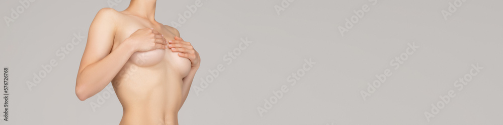 Cropped image of slim female body, breast covered with hands over grey studio background. Female health care. Concept of body and skin care, health, wellness. Banner, flyer. Copy space for ad Cropped image of slim female body, breast covered with hands over grey studio background. Female health care. Concept of body and skin care, health, wellness. Banner, flyer. Copy space for ad