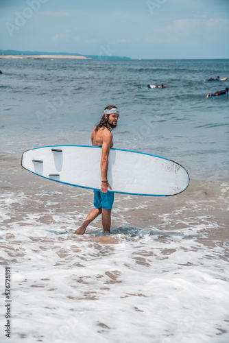 The man is surfing. A surfer on the waves in the ocean off the coast of Asia on the island of Bali in Indonesia. Sports and extreme. Beauty and health. Fashion and beach style.