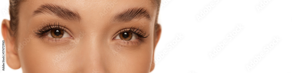 Obraz premium Cropped image of beautiful female face, eyes over grey background. Natural makeup look. Brows and lashes lamination. Concept of cosmetology, cosmetics, natural beauty. Banner, flyer. Copy space for ad