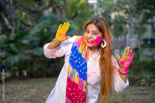 indian young girl showing colourful palm and celebrating holi