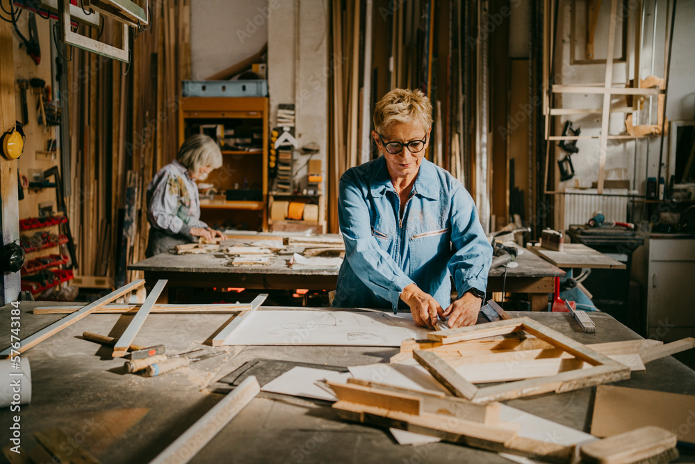 Senior craftswoman making frame at carpentry workshop