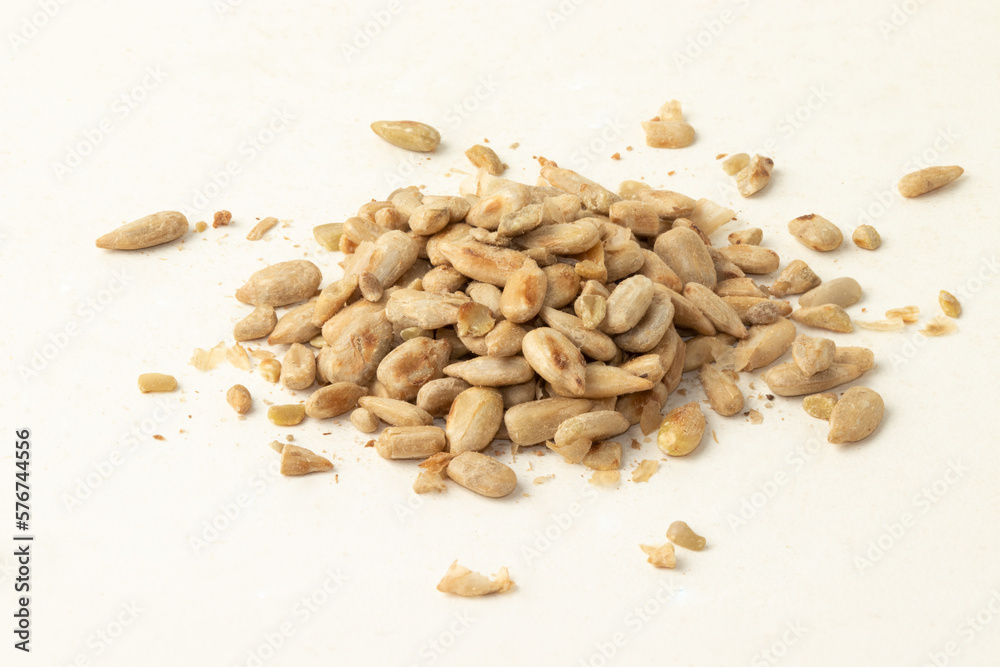 Toasted sunflower seeds on white background. Selective focus. Toasted sunflower seeds on white background. Selective focus.