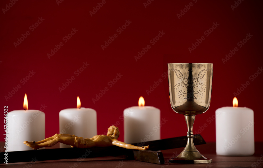 golden chalice with crucifix and burning candles red background golden chalice with crucifix and burning candles red background