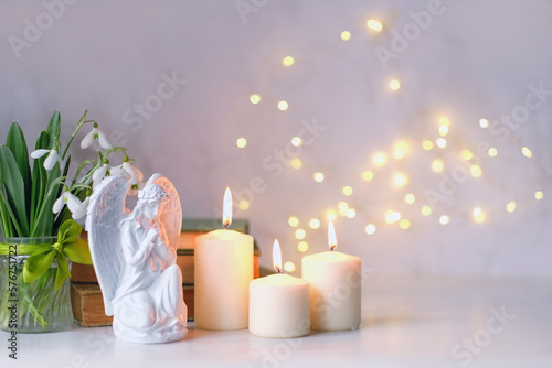 Print op canvas praying angel, candles, flowers and books on table close up, abstract light background