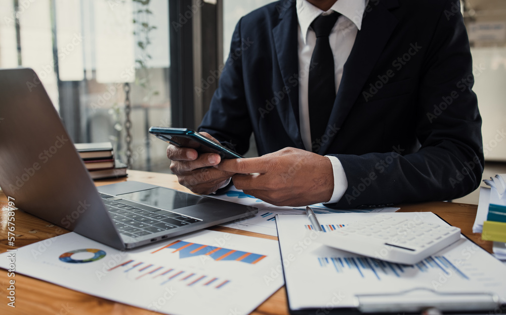 Fototapeta premium Businessman hands working on laptop computer with market report document and management business project, Business accounting concept.