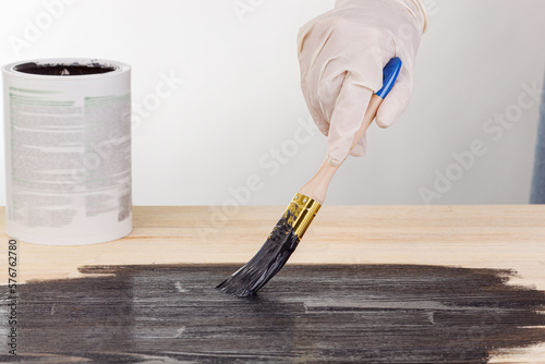 painting wooden background, hand with brush and can of paint