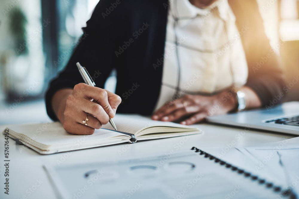 Fototapeta premium First plan is to be productive. Cropped shot of a businesswoman making notes at her desk in a modern office.