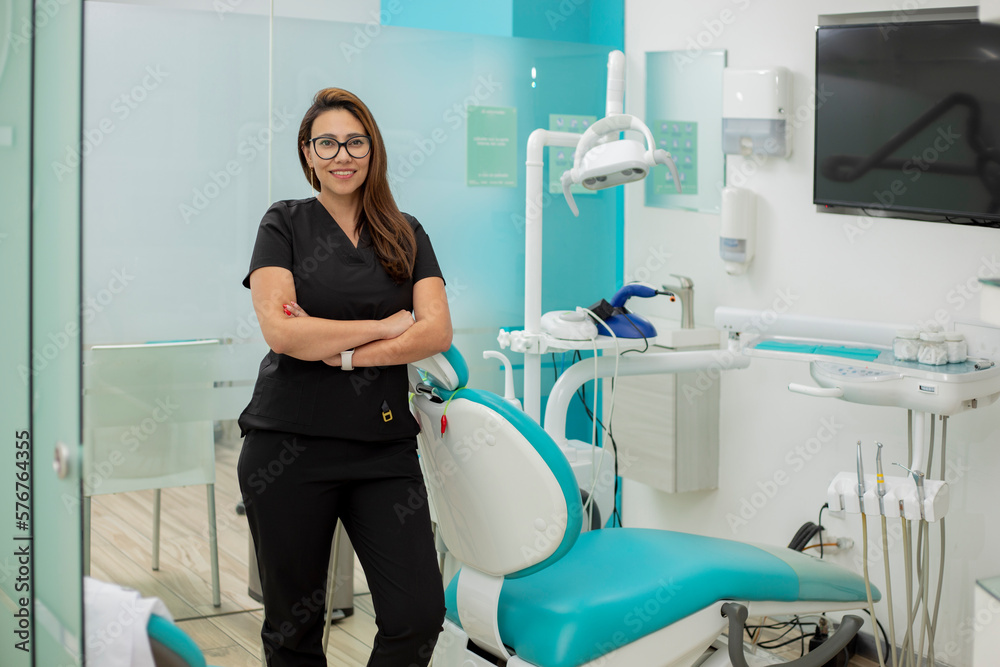 Portrait of a smiling dentist, standing in her dental surgery, with copy space. Portrait of a smiling dentist, standing in her dental surgery, with copy space.