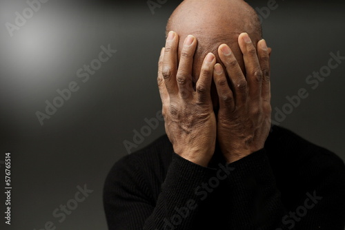 praying to god with hands together Caribbean man praying with black background stock photo