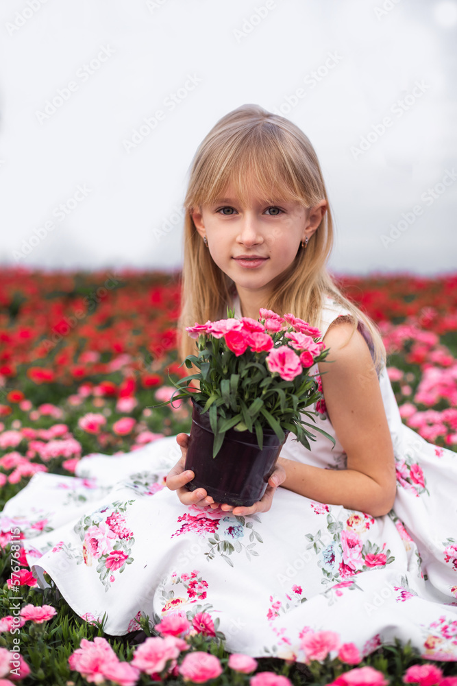 Young girl in flower greenhouse. Outdoors spring kid portrait Young girl in flower greenhouse. Outdoors spring kid portrait