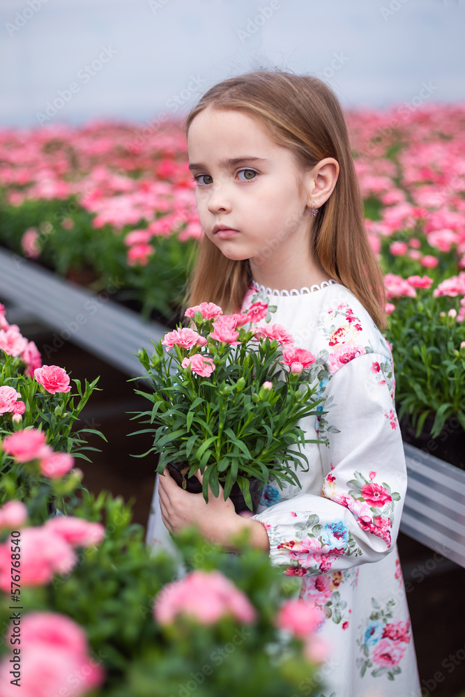 Happy cute adorable blondie caucasian little girl with flowers in greenhose. Eco friendly gardening Happy cute adorable blondie caucasian little girl with flowers in greenhose. Eco friendly gardening