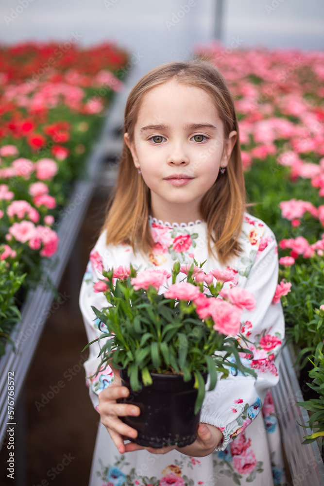 Happy cute adorable blondie caucasian little girl with flowers in greenhose. Eco friendly gardening Happy cute adorable blondie caucasian little girl with flowers in greenhose. Eco friendly gardening