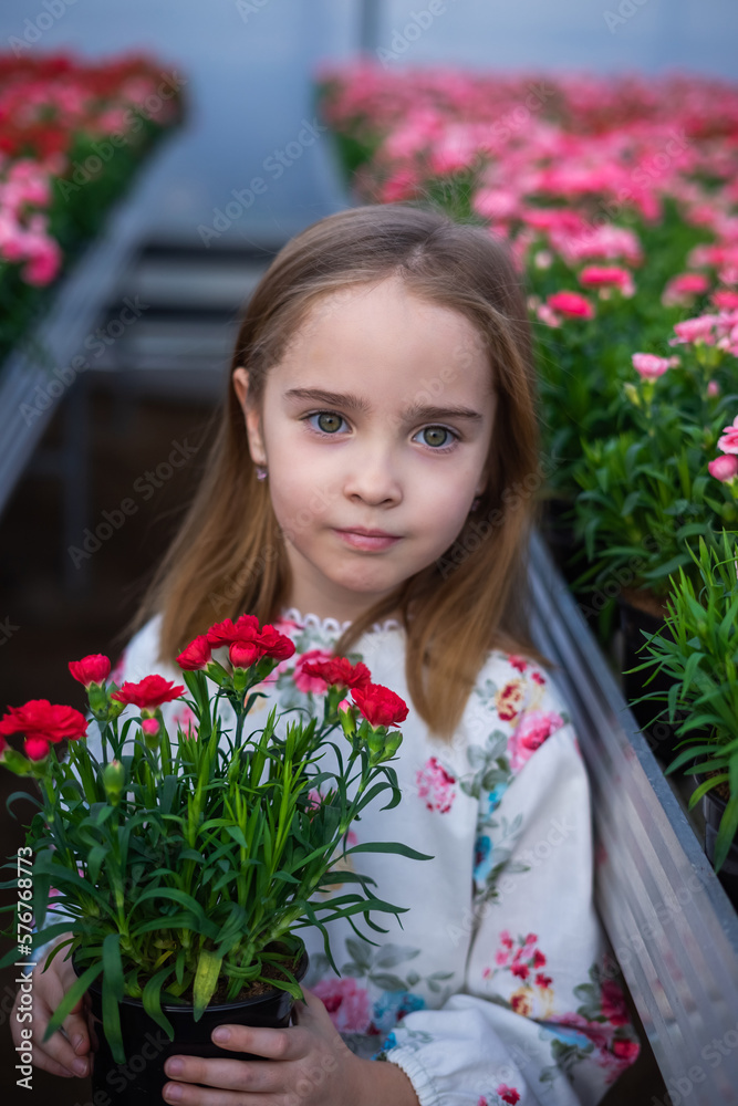 Happy cute adorable blondie caucasian little girl with flowers in greenhose. Eco friendly gardening Happy cute adorable blondie caucasian little girl with flowers in greenhose. Eco friendly gardening