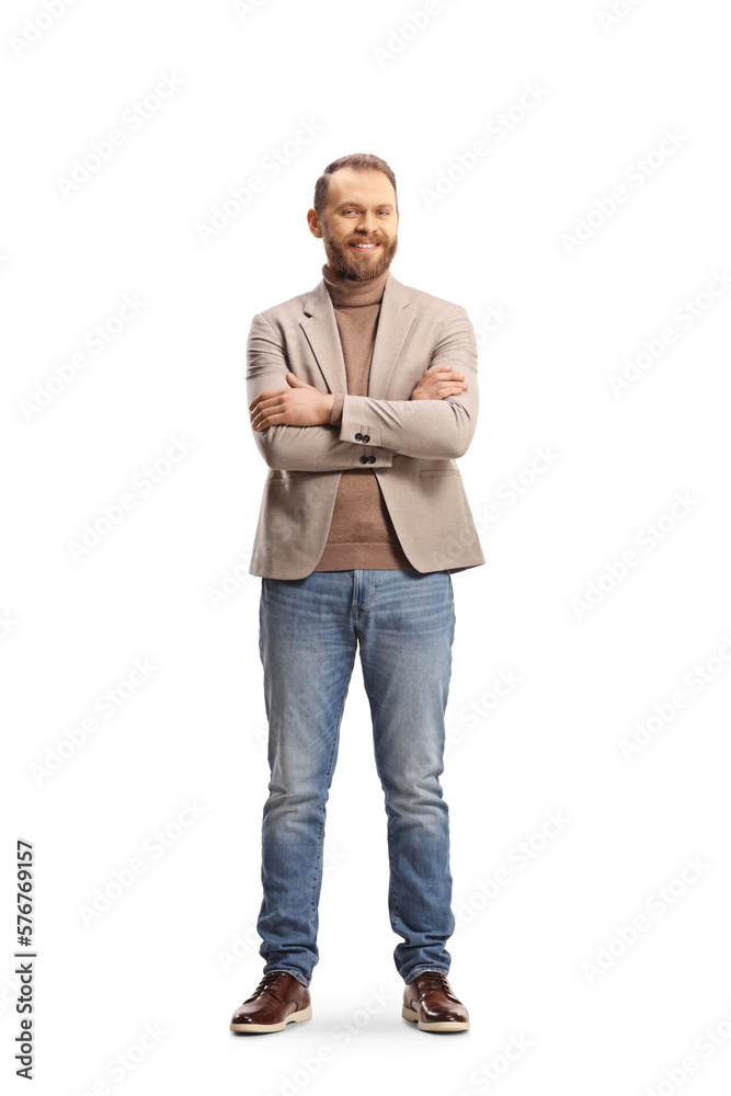 Full length portrait of a man in a beige suit and jeans posing with crossed arms Full length portrait of a man in a beige suit and jeans posing with crossed arms