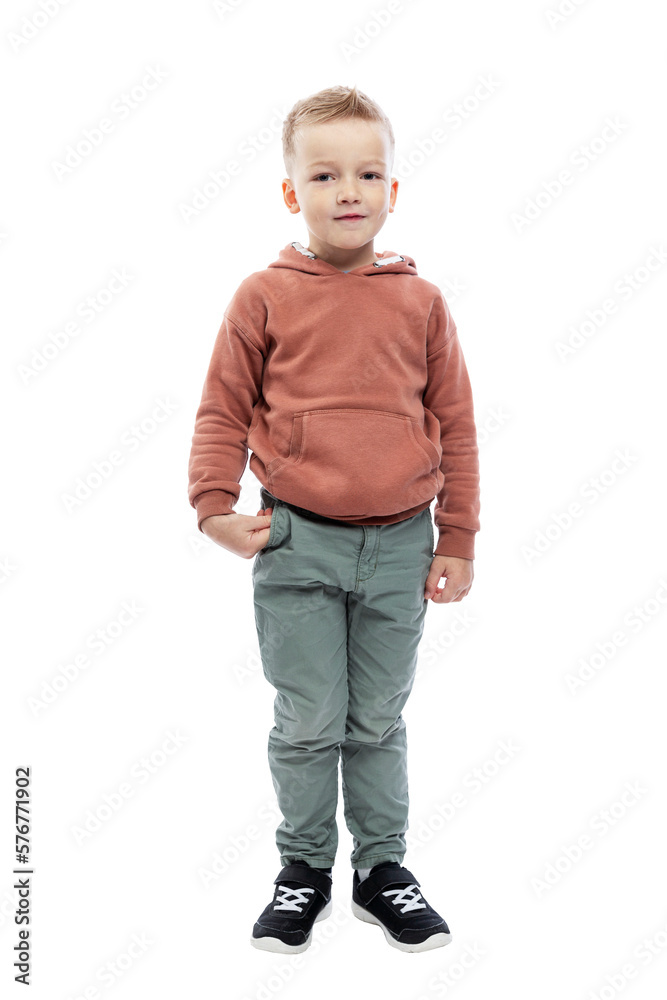 Smiling boy is standing. A cute blond man with a trendy hairstyle in a brown hoodie and gray trousers. Joy and positivity. Full height. Isolated on white background. Vertical. Smiling boy is standing. A cute blond man with a trendy hairstyle in a brown hoodie and gray trousers. Joy and positivity. Full height. Isolated on white background. Vertical.