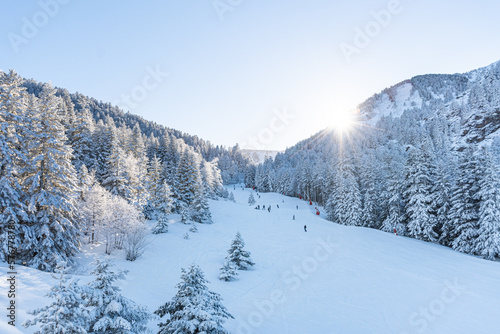People enjoying the landscape with bright sun in the snow doing outdoor sport in winter, skiing in a ski resort on holiday. Lifestyle