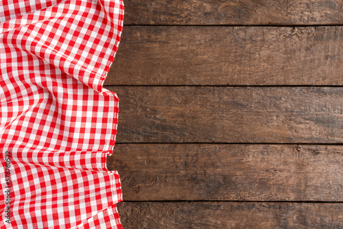 Checkered tablecloth on wooden background. Top view