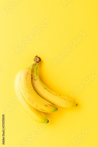 Bunch of fresh bananas on yellow background with copyspace. Top view