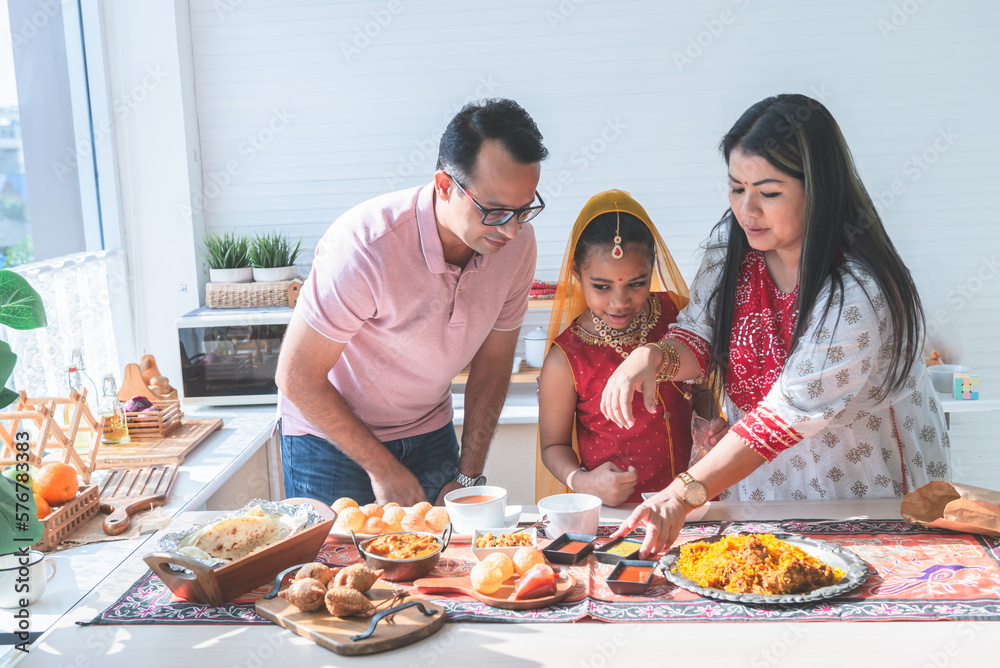 an Indian family standing in the kitchen They help each other prepare the food that they ordered. Arrange in a container placed on the table, to family and Indian food concept. an Indian family standing in the kitchen They help each other prepare the food that they ordered. Arrange in a container placed on the table, to family and Indian food concept.