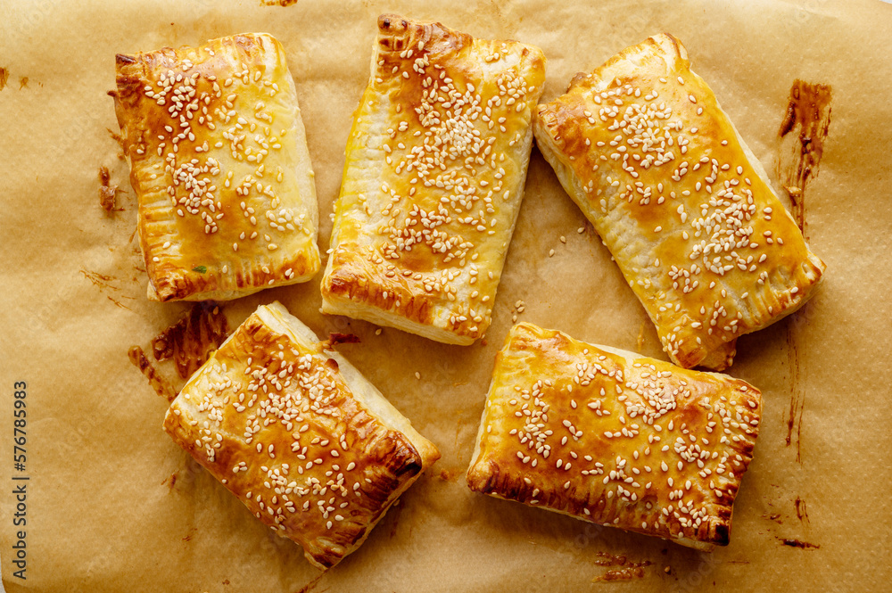 Puff pastry dough. Folded baked puff pastry pies portions, top view