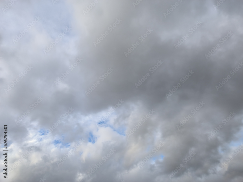 Large mass of grayish and whitish clouds in the blue sky
