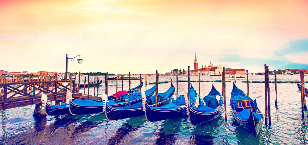 Magic cityscape with gondolas on the San Marco canal on the background of Church of San Giorgio Maggiore at at dawn. Amazing places. Popular tourist atraction.