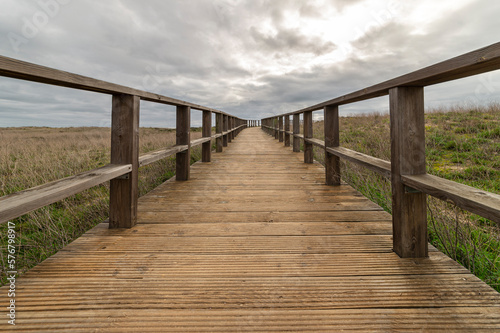 Wooden boardwalk with a cloudy sky