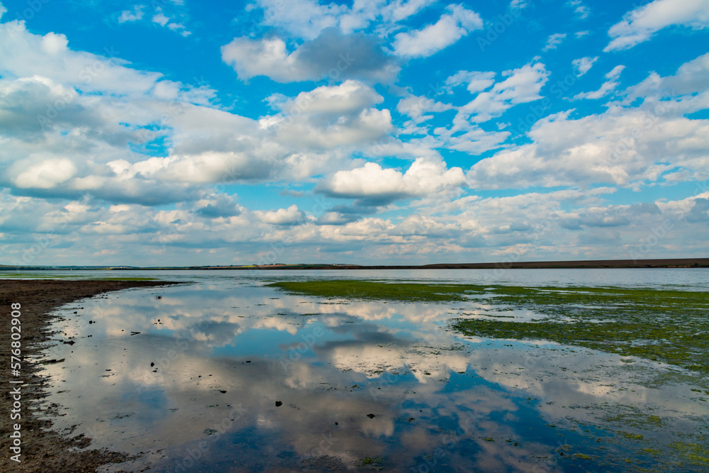 Reflection of white storm clouds in the water of the Tiligul estuary, Ukraine Reflection of white storm clouds in the water of the Tiligul estuary, Ukraine