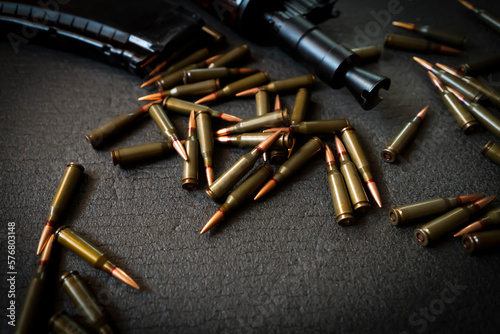 An assault rifle, weapons with a cartridges on a dark background.