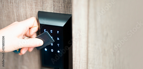 A girl is opening a door with a smart card - key, a modern lock.