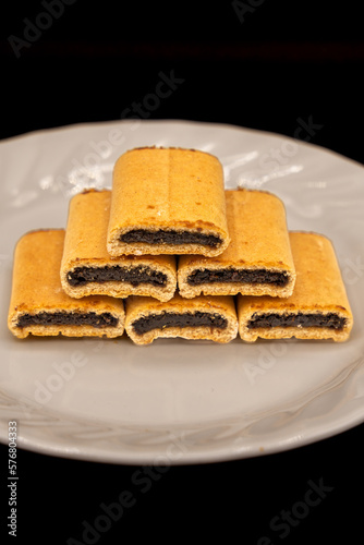 Fig Newton cookies on a white plate on a black background.