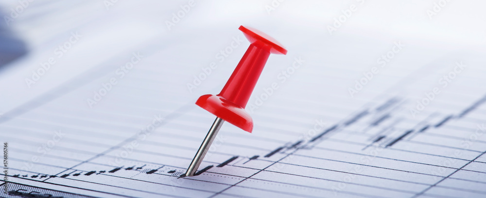 Marking financial chart by pins.Share listing and checking financial chart. Concept of banking, financial report and financial audit. Marking financial chart by pins.Share listing and checking financial chart. Concept of banking, financial report and financial audit.