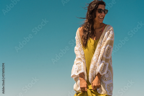 woman on the beach wearing a crochet cardigan made with granny squares  crochet outfit.Outfit spring summer