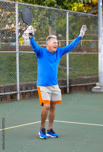 Active Senior Man playing Pickle Ball outdoors